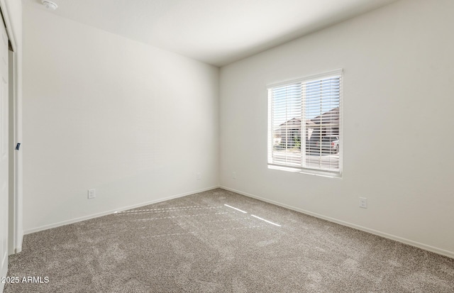 unfurnished room featuring carpet flooring and baseboards