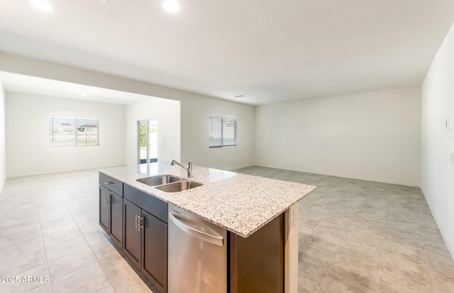 kitchen with a sink, open floor plan, dark brown cabinets, stainless steel dishwasher, and an island with sink