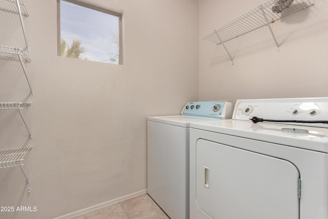 laundry area featuring washer and clothes dryer and light tile patterned floors