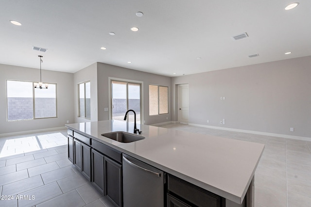 kitchen with pendant lighting, dishwasher, sink, an island with sink, and a chandelier