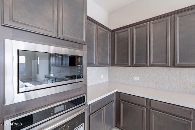 kitchen featuring decorative backsplash, dark brown cabinets, and stainless steel appliances