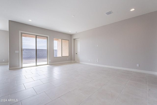 empty room featuring a water view and light tile patterned floors