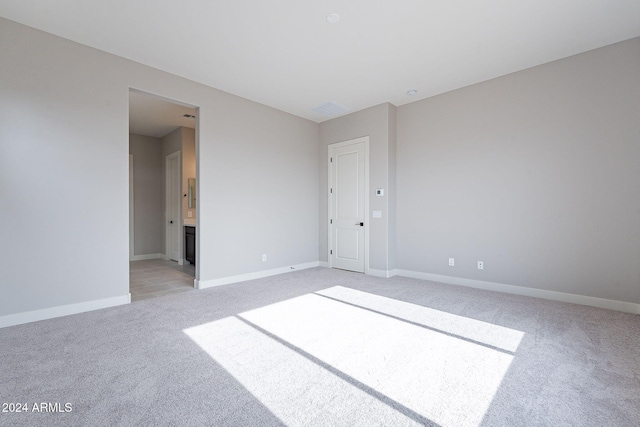 unfurnished room featuring light colored carpet