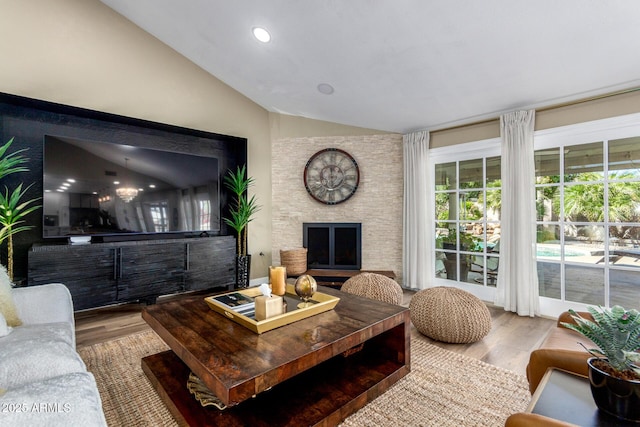 living room featuring lofted ceiling, a fireplace, wood finished floors, and recessed lighting