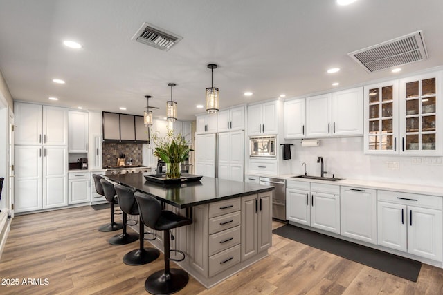 kitchen featuring appliances with stainless steel finishes, a sink, visible vents, and a center island