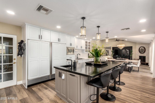 kitchen featuring stainless steel microwave, a sink, and visible vents