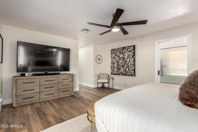 bedroom with dark wood-style floors, ceiling fan, visible vents, and baseboards