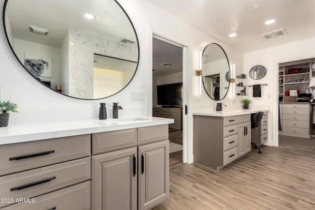 bathroom featuring visible vents, a sink, and wood finished floors