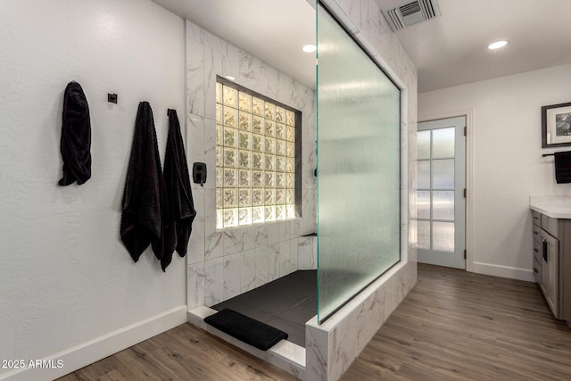 full bath with a walk in shower, visible vents, baseboards, and wood finished floors