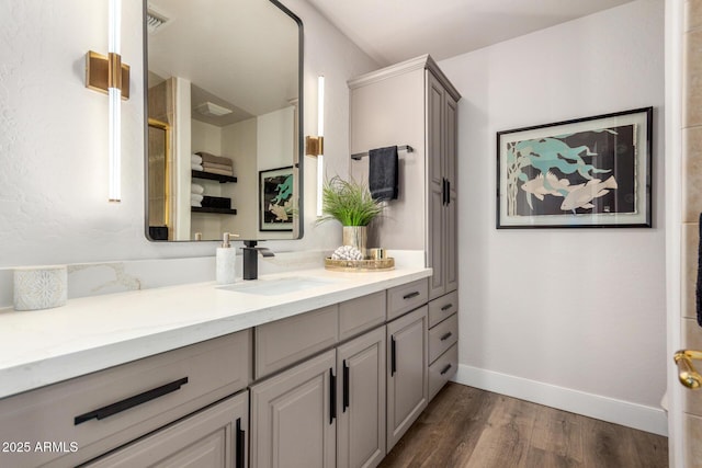 full bath featuring visible vents, baseboards, wood finished floors, and vanity