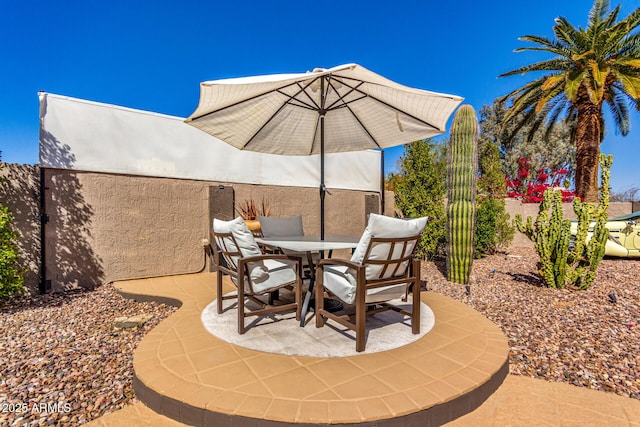 view of patio with outdoor dining area and fence