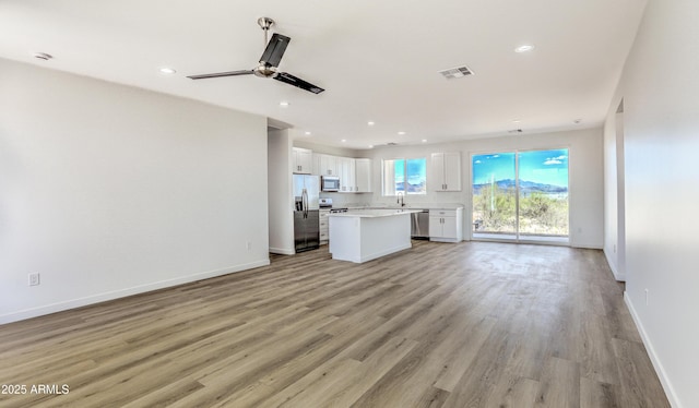 16025 E Rancho Laredo Dr, Scottsdale, AZ 85262 - unfurnished living room featuring light wood-type flooring, baseboards, recessed lighting, a ceiling fan, and a sink