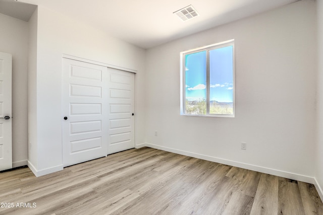 16025 E Rancho Laredo Dr, Scottsdale, AZ 85262 - unfurnished bedroom with light wood-style floors, a closet, and baseboards