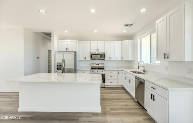 16025 E Rancho Laredo Dr, Scottsdale, AZ 85262 - kitchen with appliances with stainless steel finishes, a sink, a center island, white cabinets, and light stone countertops