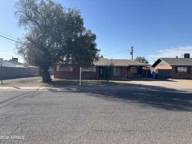 single story home featuring fence and brick siding