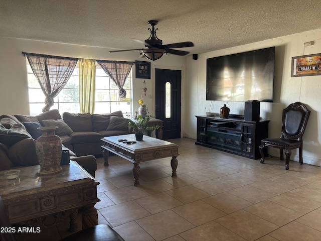 living room featuring a ceiling fan, a textured ceiling, and tile patterned floors