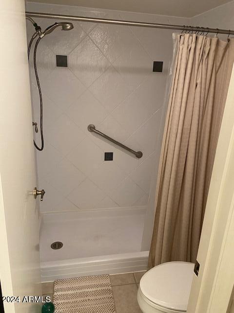 bathroom with tile patterned floors, toilet, and a shower with shower curtain