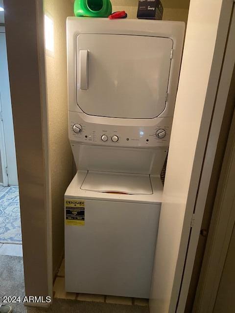 washroom featuring stacked washing maching and dryer