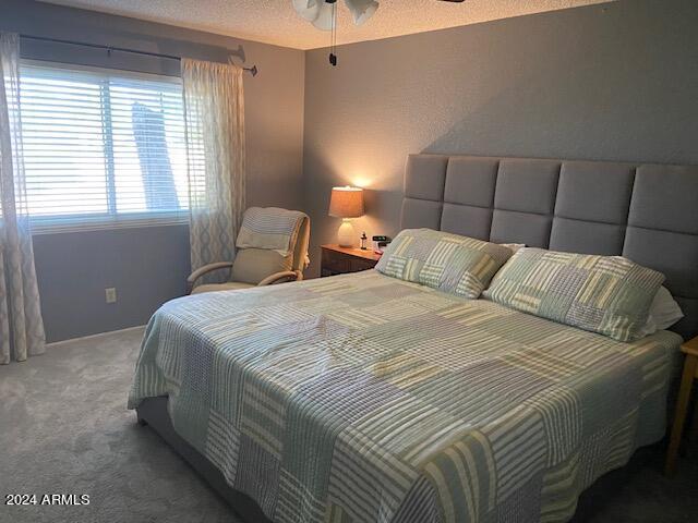 bedroom with carpet and a textured ceiling