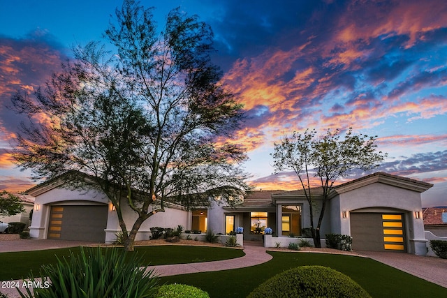 view of front of property with a garage and a lawn