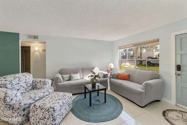 tiled living room featuring a textured ceiling