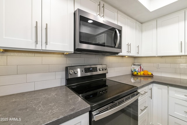 kitchen with white cabinetry, decorative backsplash, and stainless steel appliances