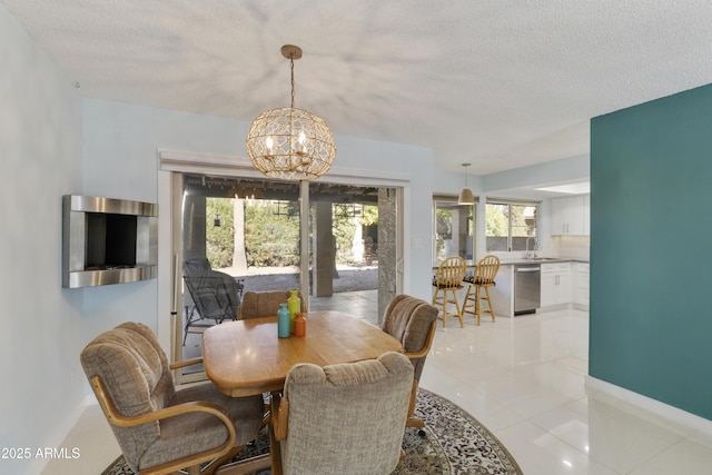 dining space with sink, a textured ceiling, light tile patterned floors, and a chandelier