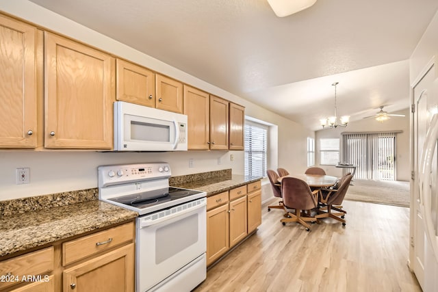 kitchen featuring ceiling fan with notable chandelier, white appliances, vaulted ceiling, light hardwood / wood-style floors, and hanging light fixtures