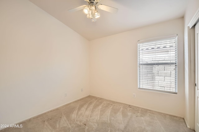 carpeted spare room with a wealth of natural light and ceiling fan