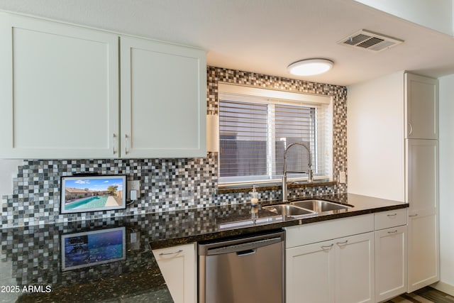 kitchen with visible vents, dishwasher, backsplash, dark stone countertops, and a sink