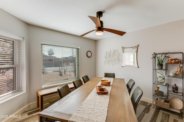 dining space featuring light wood-style floors, ceiling fan, and baseboards