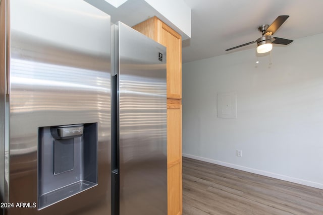 kitchen featuring ceiling fan, electric panel, stainless steel fridge, wood-type flooring, and light brown cabinetry