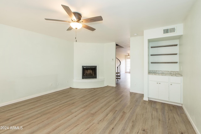 unfurnished living room with light wood-type flooring and ceiling fan