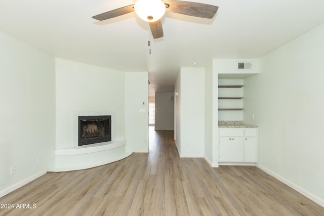 unfurnished living room with light hardwood / wood-style flooring and ceiling fan