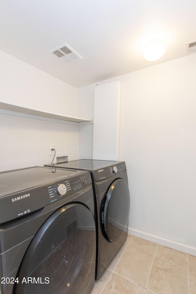 laundry room featuring light tile patterned floors and separate washer and dryer