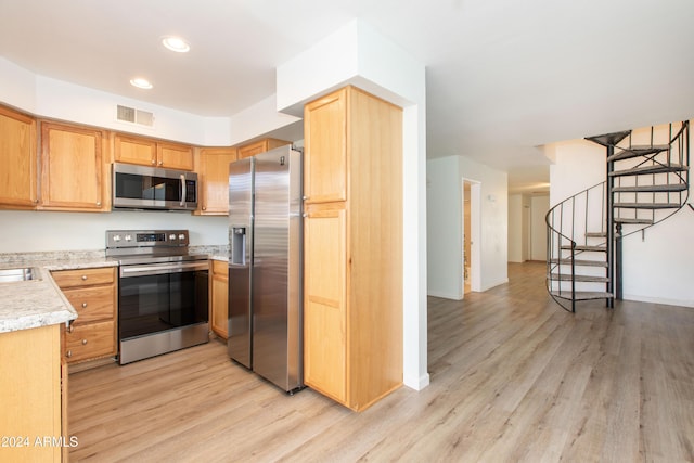 kitchen with stainless steel appliances and light hardwood / wood-style floors