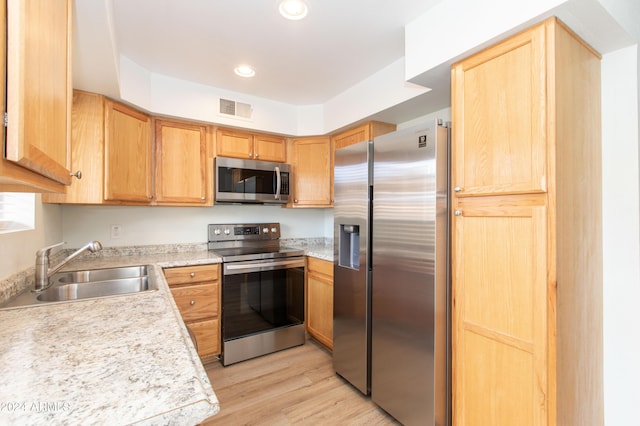 kitchen with light wood-type flooring, sink, and appliances with stainless steel finishes