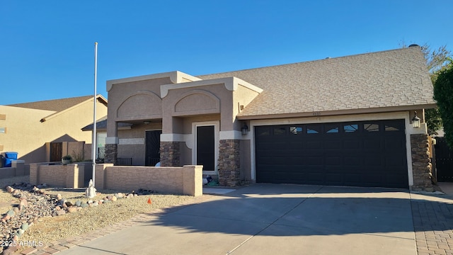 view of front facade with an attached garage, stone siding, driveway, and a shingled roof