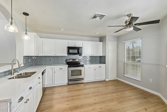 kitchen featuring visible vents, a sink, decorative backsplash, light countertops, and stainless steel appliances