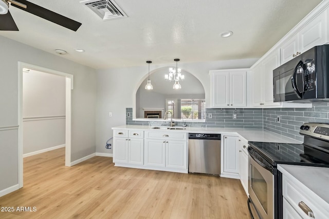 kitchen featuring visible vents, a sink, decorative backsplash, appliances with stainless steel finishes, and white cabinetry