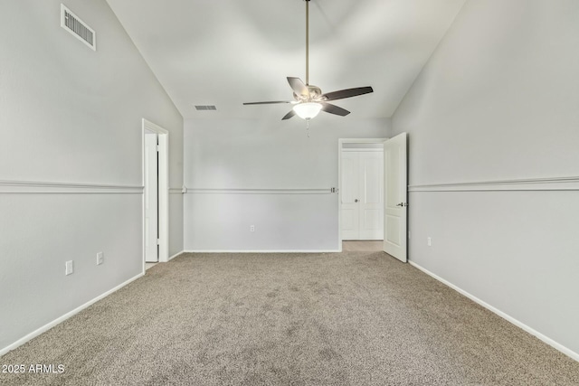 spare room with visible vents, carpet flooring, a ceiling fan, and lofted ceiling