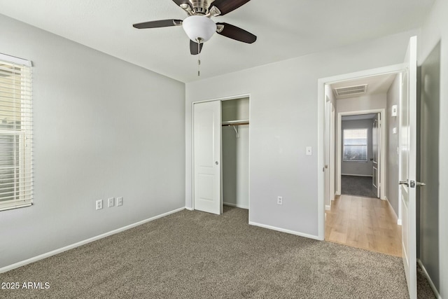 unfurnished bedroom with visible vents, baseboards, carpet, a closet, and a ceiling fan