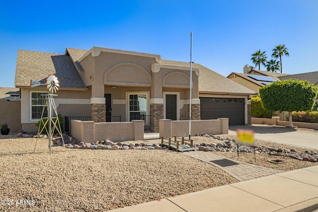 view of front of house featuring stucco siding, stone siding, fence, concrete driveway, and a garage