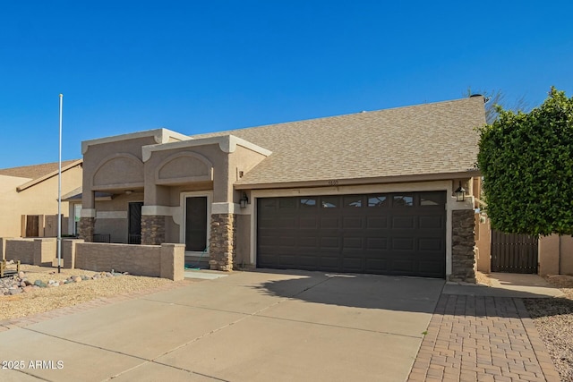 view of front of property with roof with shingles, driveway, stucco siding, a garage, and stone siding