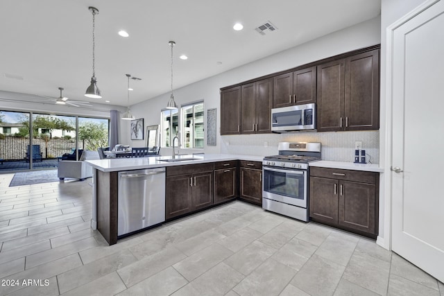 kitchen featuring ceiling fan, sink, tasteful backsplash, decorative light fixtures, and appliances with stainless steel finishes