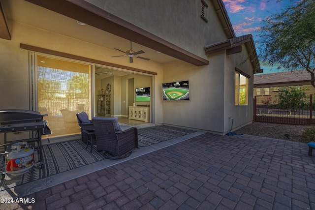 patio terrace at dusk featuring ceiling fan