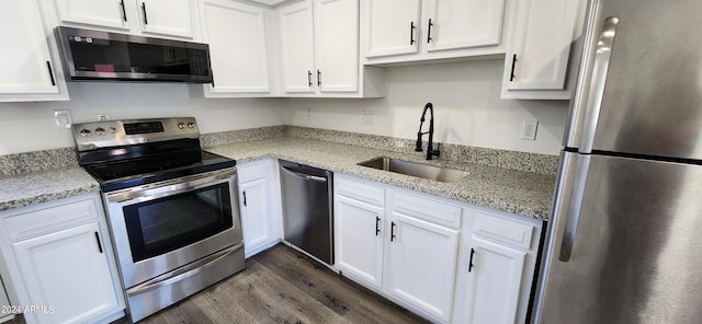 kitchen with sink, stainless steel appliances, white cabinetry, and light stone counters