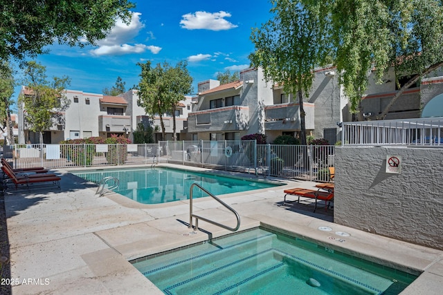 pool featuring a hot tub, a residential view, fence, and a patio