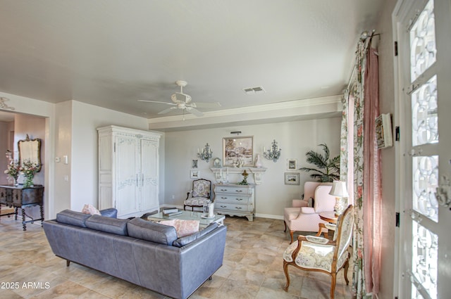 living room with visible vents, baseboards, and ceiling fan