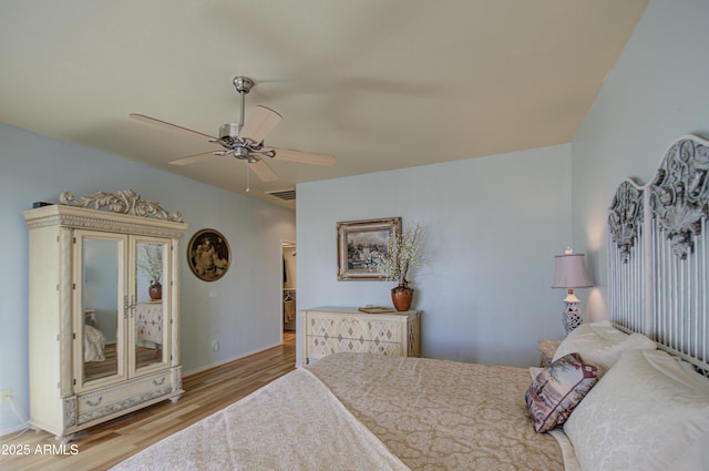 bedroom featuring ceiling fan, visible vents, and wood finished floors